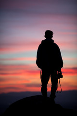 silhouetted photographer in sunset sky