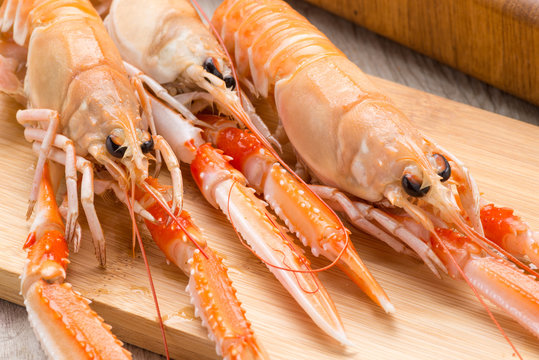 Scampi crudi sul tagliere di legno