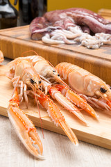 Scampi crudi sul tagliere di legno
