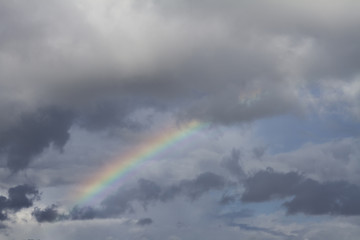 View of a beautiful rainbow on a cloudy sky.