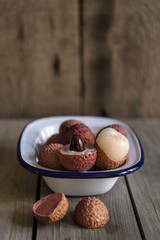 Lychees in rustic setting with wooden background
