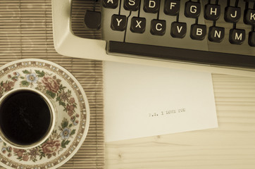 Coffee cup, typewriter and I love you message. Old photo style