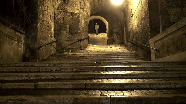 Guy at night down the  stone steps