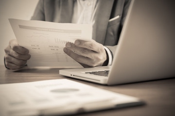 Businessman analyzing investment charts with laptop. Accounting