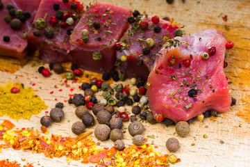 raw meat and spices on wooden stand