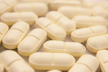 Fototapeta na wymiar Spilled pills toned in brown background
