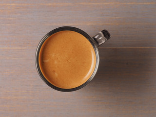 Cup of hot espresso coffee and coffee crop on wood board