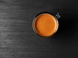 Cup of hot espresso coffee and coffee crop on wood board