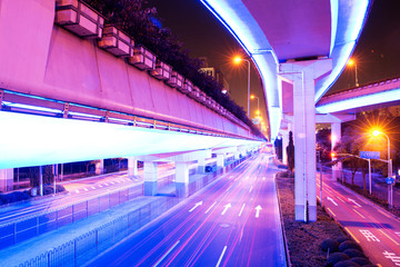 illuminated traffic on elevated expressway in modern city.