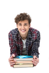 Happy young man leaning on the desk with books