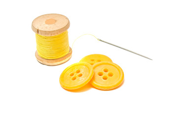 buttons and spool of yellow thread