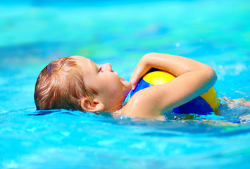 Fototapeta na wymiar cute kid playing water sport games in pool