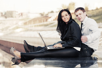 Young business couple with laptop outdoor