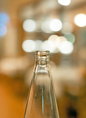 Neck of a glass bottle over bokeh.