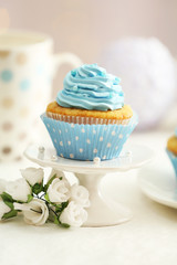 Delicious cupcakes on table on light background
