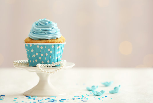 Sweet cupcake on table on light background