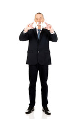 Fototapeta premium Businessman trying to connect puzzle pieces.