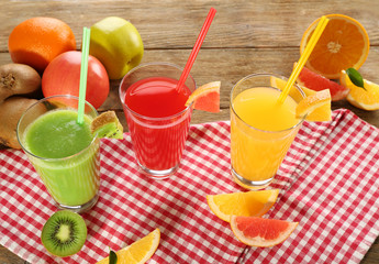 Fresh juices with fruits on wooden table