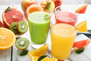 Fresh juices with fruits on wooden table