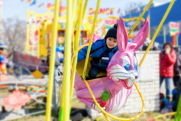 Adorable little boy, swinging on a pink rabbit