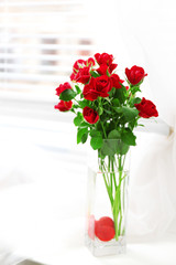 Bouquet of red roses in glass vase with heart