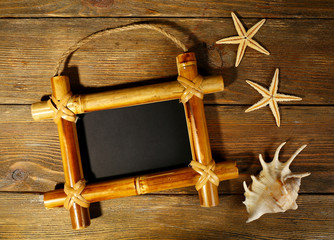 Sign board with shell and sea stars on wooden background