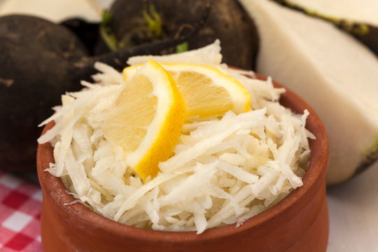 Grated black radish salad with lemon slices