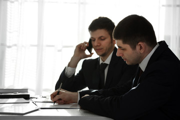 Two handsome businessmen working in office