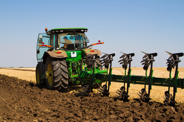 Agricultural tractor plowing a field
