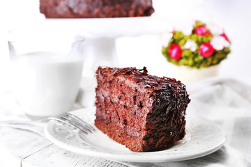 Sliced tasty chocolate cake in plate and glass of milk