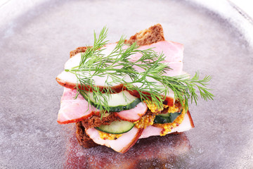 Delicious sandwich with ham, cucumber and mustard
