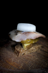 Canape with herring, potato, cucumber and onion