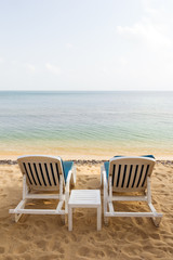Fototapeta na wymiar Two beach chairs at the empty Maenam Beach in Koh Samui