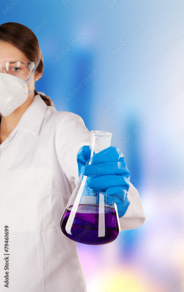 Wall mural woman in laboratory holding chemical liquid in glass flask