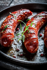 Roasted sausage with fresh rosemary on hot barbecue dish