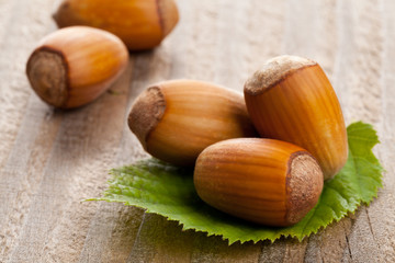 Hazelnuts with hazelnut leaf on wooden background