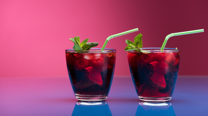 Raspberry and blackberry cocktail with mint garnish. Studio shot