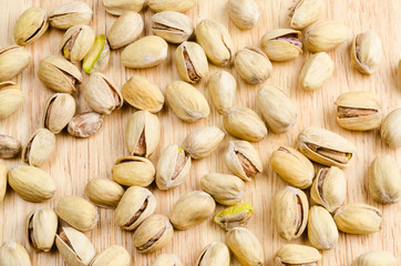 roasted and salted pistachios on wooden background