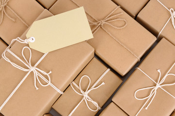 Pile or heap of several lots brown paper wrapped parcel package or gift boxes and label gift tag photo