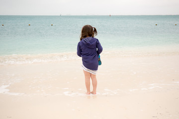 girl child on beach sand white ocean blue cute