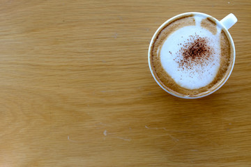 cup of hot cappuccino on the wooden table