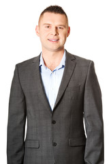 Happy young businessman looking at camera