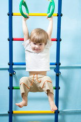 child hanging on gymnastic rings