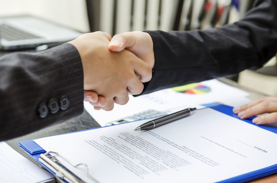 Business person shaking hands as a deal done
