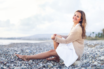 Fototapeta na wymiar Young woman on the beach enjoying a warm summer evening
