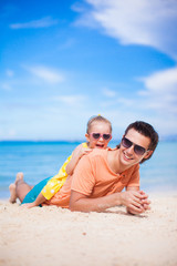 Happy father and adorable little daughter on the beach