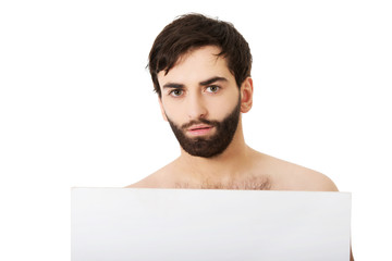 Young shirtless man holding empty banner.