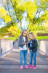 Fototapeta premium Adorable little girls at warm autumn day outdoors
