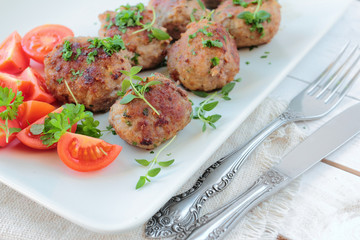 Meatballs with parsley and thyme herbs on a white plate