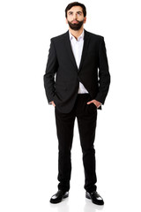 Thoughtful businessman with hands in pockets.